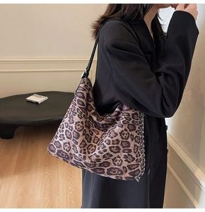 Detail of leopard print hobo bag with black shoulder strap and side metal chain link