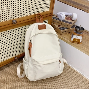 Close-up of ivory school backpack with brown leather handle and kunkang logo