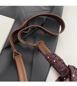 Detail of brown litchi leather strap with purple polka dot silk scarf and gold buckle