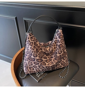 Detail of leopard print hobo bag with leather handle and silver metal chain strap
