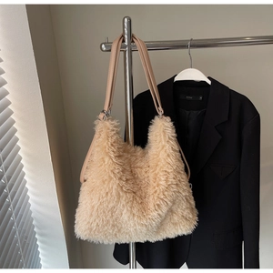 Detailed view of plush apricot faux fur tote bag with smooth leather straps and silver rings