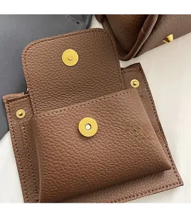Macro view of brown lychee leather bag showing magnetic closure and front pocket detail