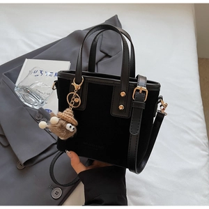 Détail du sac seau en velours noir avec clous dorés et pendentif en peluche mignon