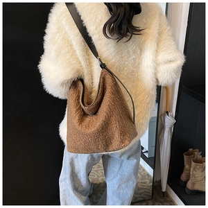 Brown faux fur Hobo shoulder bag with black leather strap shown on a person