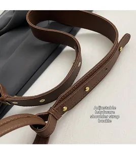 Detail of adjustable leather strap with gold buckle on brown bucket bag