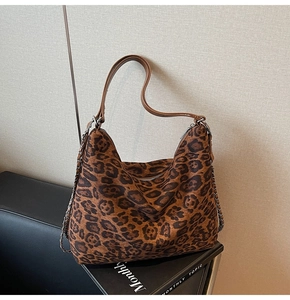 Close-up of leopard print tote bag with soft faux suede texture and silver chain detail
