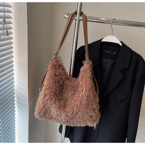 Detail of soft brown plush tote bag with slim faux leather shoulder straps and metal rings