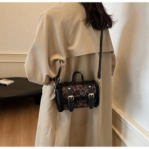 Détail du sac bandoulière léopard avec bordure en fausse fourrure et boucles dorées sur modèle