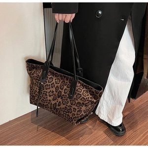 Macro shot of large leopard print tote bag detailing durable fabric and black handles