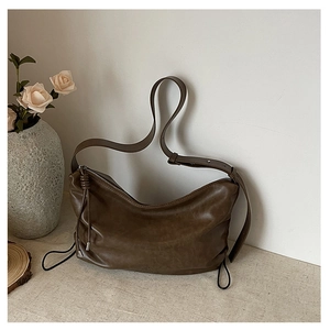 Detail of soft dark brown coffee pleated tote with adjustable strap and metallic accents