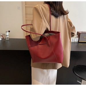 Detail view of burgundy leather tote bag with vertical stitching and slim straps