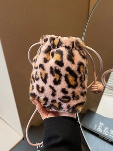 Stylish leopard print plush bucket bag with pink drawstrings and sleek leather strap