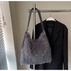 Detail of dark gray faux fur tote bag with black leather straps and silver metal chain