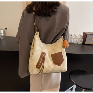 Detail of vintage canvas tote with brown leather strap and cute brown plush bear charm