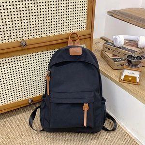Detail view of the black school backpack with leather accents and durable zipper pulls