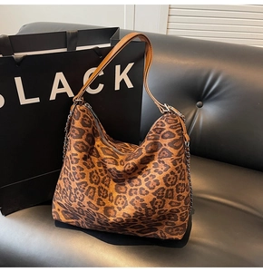 Detailed view of leopard print hobo bag with leather strap and decorative metal chain