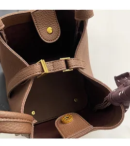 Detail of brown litchi leather bucket bag showing magnetic clasp and polka dot scarf
