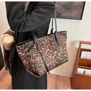 Macro detail of large leopard print tote bag with sturdy black shoulder straps and spacious interior