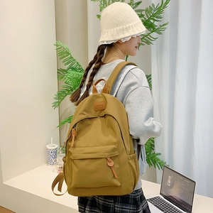 Side view of ginger yellow canvas backpack showing side pockets and leather zipper pullers