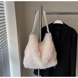 Detail of soft cream plush shoulder bag featuring faux fur texture and slim leather strap
