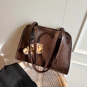 Détail du sac fourre-tout vintage en cuir marron foncé avec breloque ours léopard