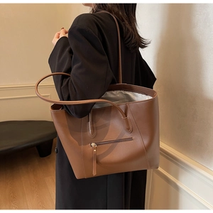 Lifestyle shot of large brown leather tote bag with front zipper and spacious interior