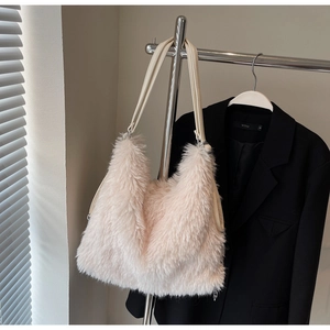 Detail of soft plush shoulder bag with smooth cream leather straps on a hanger