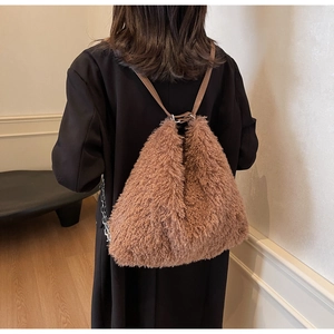 Detailed view of plush brown faux shearling backpack texture with leather straps on model