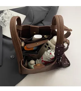 Internal view of brown leather bucket bag showing large capacity with silk scarf detail