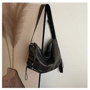 Detail of the black leather hobo bag with tassel drawstring and adjustable wide strap