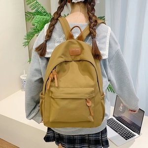 Detail of khaki canvas backpack featuring leather drawstring and side water bottle pocket