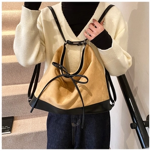 Detail of camel suede backpack with black leather base and elegant bow decoration