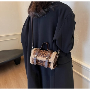 Détail d'un sac tonneau léopard avec bordure en peluche beige et boucles doubles