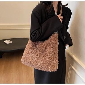 Detail of plush faux fur brown tote bag with metal chain strap and long shoulder strap