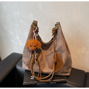 Detail of vintage canvas tote with rope knot handles and brown puppy plush charm