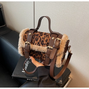 Gros plan du sac cylindre léopard avec bordure en fourrure et boucles métalliques