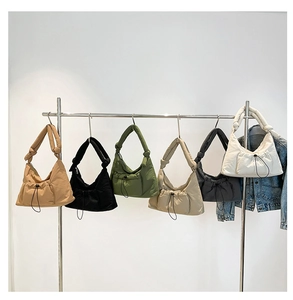 Detail showing various colors of quilted nylon crossbody dumpling bags on hangers