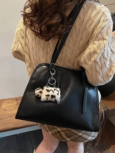 Sac fourre-tout noir rétro en cuir avec breloque vache sur banc pour look d'automne