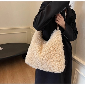 Detail of soft cream faux shearling tote bag styled with a professional black blazer jacket