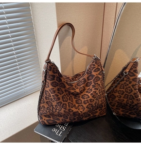 Close-up of leopard print tote bag featuring leather strap and silver chain detail