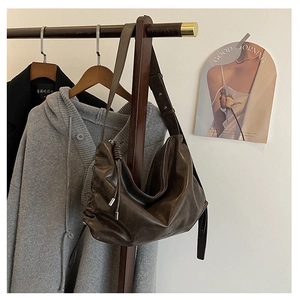 Detail view of dark brown vintage faux leather shoulder bag with side drawstring accents