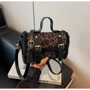 Détail du sac léopard en daim avec boucles dorées et bordure en fausse fourrure