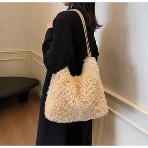 Detail of soft beige faux fur tote bag showing plush texture on model with black coat