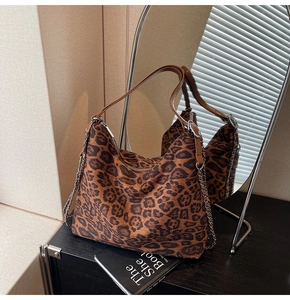 Detailed view of leopard print tote bag with brown straps and silver chain decoration