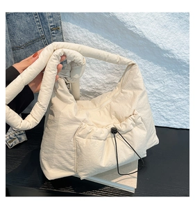 Detailed macro view of the cream quilted nylon bag with knot shoulder strap and drawstring pocket