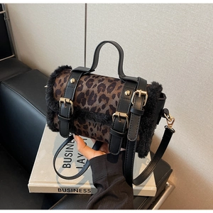 Détail du sac cylindre imprimé léopard avec bordure en fourrure et boucles dorées