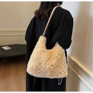 Detail of plush faux fur shoulder bag in cream with leather strap and metal chain