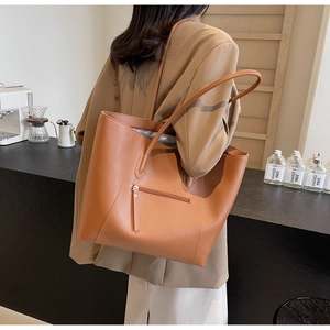 Brown leather tote bag featuring a functional back zipper pocket and long shoulder straps