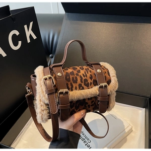 Détail du sac léopard avec garniture en fausse fourrure et boucle sur boîte cadeau noire