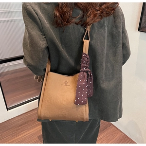 Brown lychee texture bucket bag featuring a decorative polka dot silk scarf detail